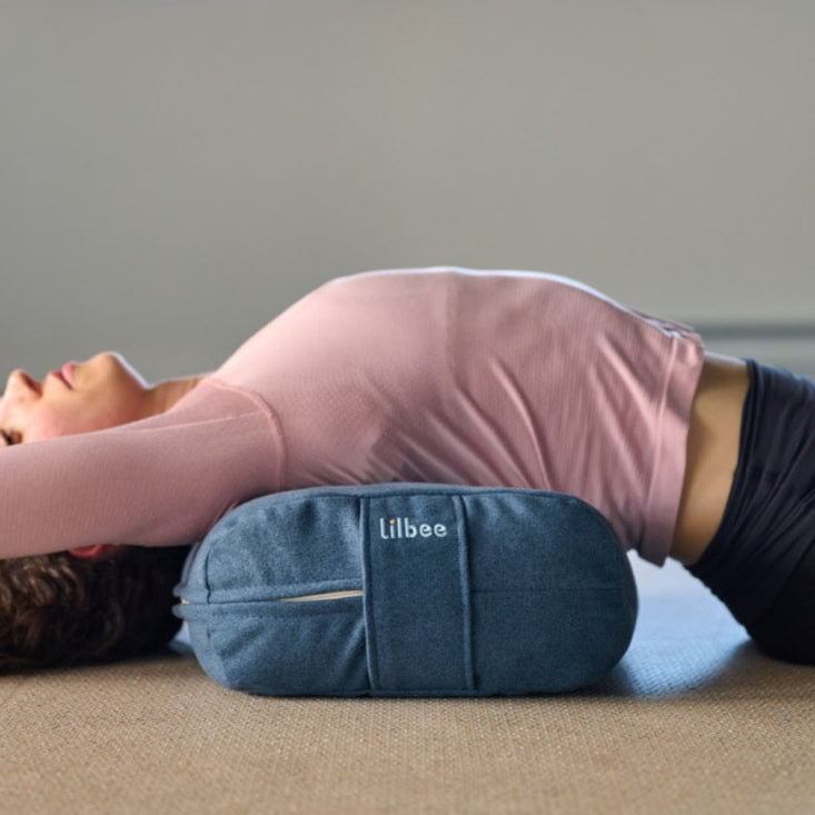 Yoga practitioner supported by a Lilbee rectangular bolster under the upper back. Perfect for chest opening and restorative yoga. Handmade in Canada from recycled fabrics for sustainable comfort.